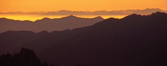 A view of the distant mountains layered against the glowing golden sunset