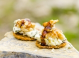 Walnuts, blue cheese, honey, multigrain crackers on a rock slab
